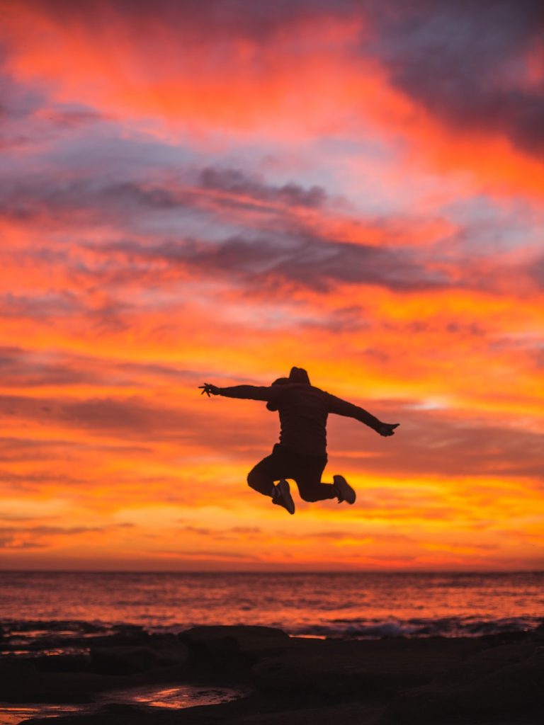 silhouette of person jumping above ground